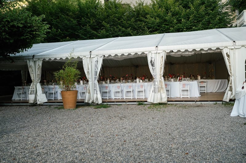 Open sided marquee set with long tables before service at Abbaye de Talloires