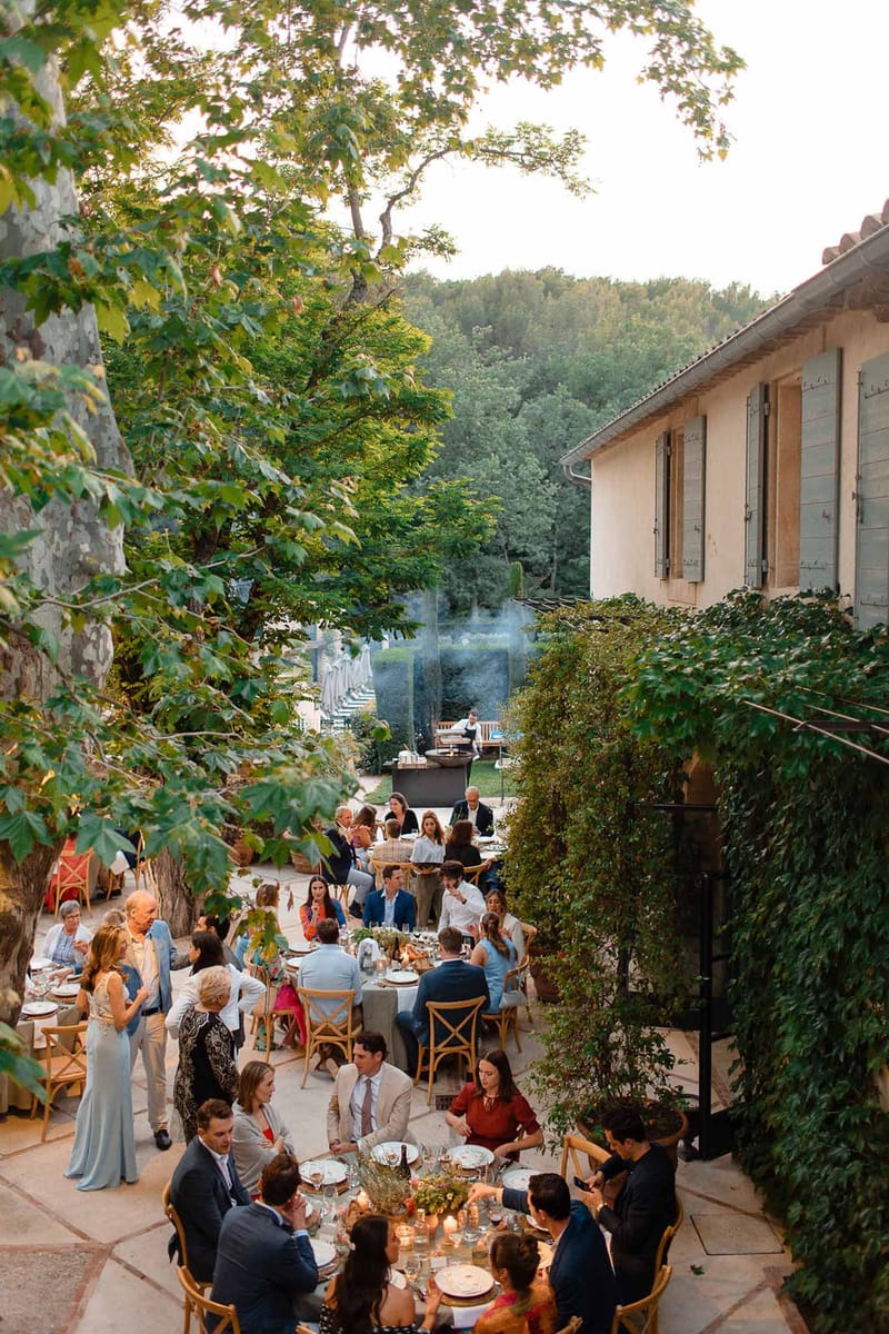 Elevated view of terrace reception with cross-back chairs and candlelit tables at Provencal farmhouse