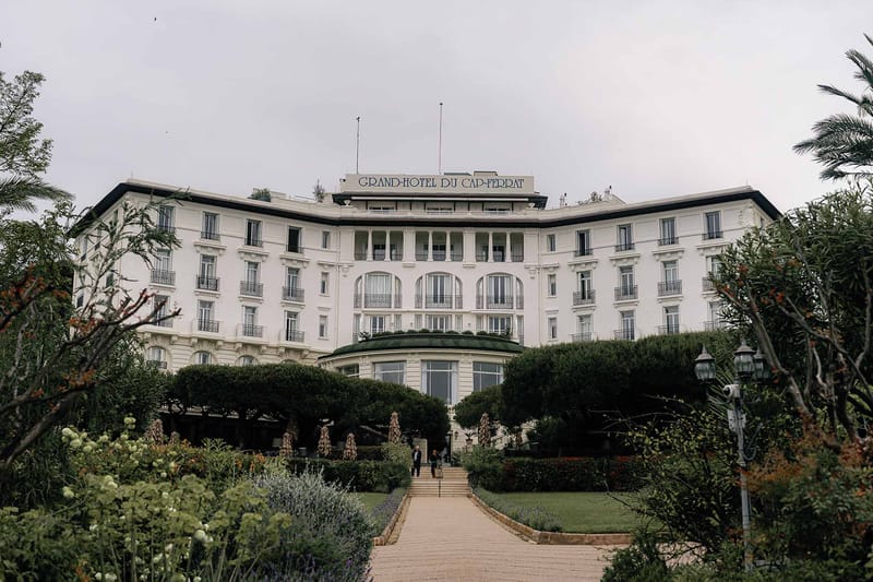 Grand-Hotel du Cap-Ferrat Belle Epoque facade with arched windows, topiary gardens, and paved pathway