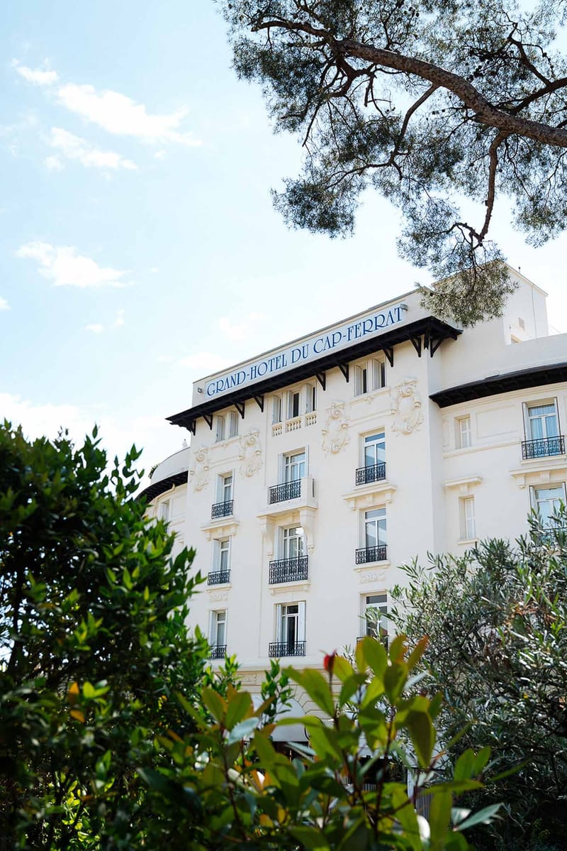 Grand-Hotel du Cap-Ferrat white Belle Epoque facade with wrought-iron balconies and blue rooftop sign