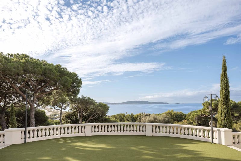 Curved white stone balustrade terrace with lamp posts overlooking panoramic sea view on French Riviera