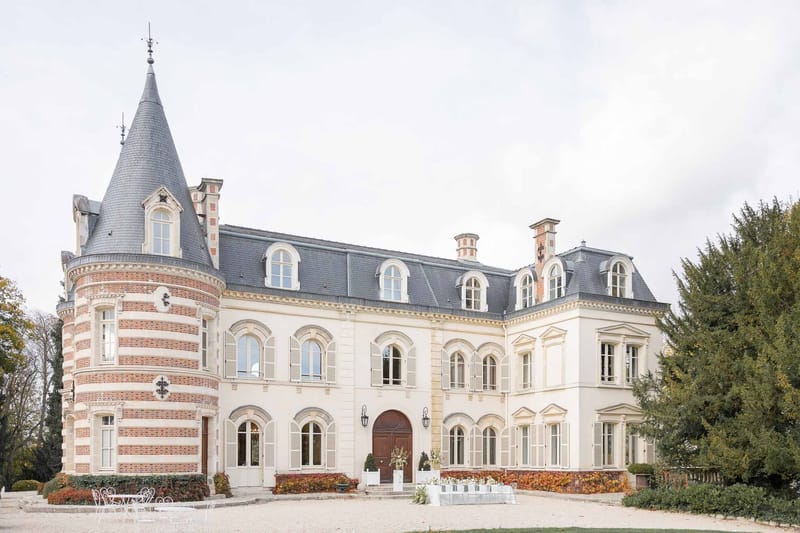 Side view of Château Comtesse Lafond with turret and autumn trees in Épernay