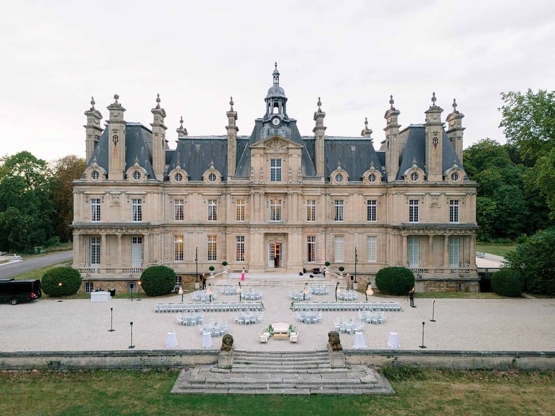 Aerial view of Second Empire chateau with ceremony chairs and cocktail tables arranged on gravel forecourt