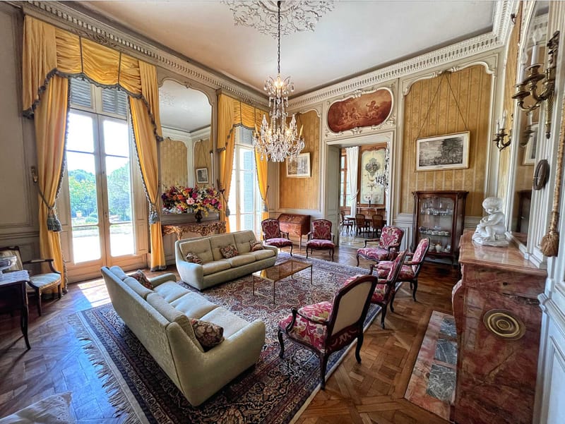 Grand salon interior of French chateau with crystal chandelier herringbone floors and period furnishings