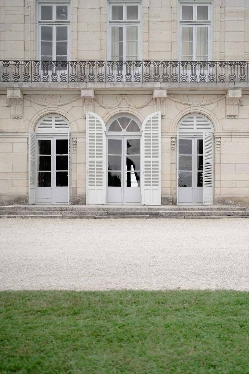 View of Chateau d'Arcelot garden through a vintage window