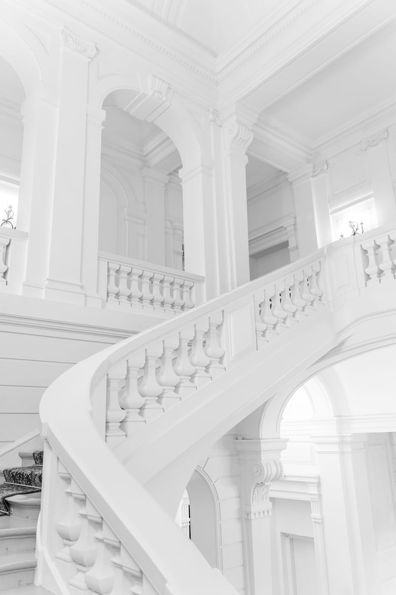 White vintage staircase and ceiling inside Domaine des Halles
