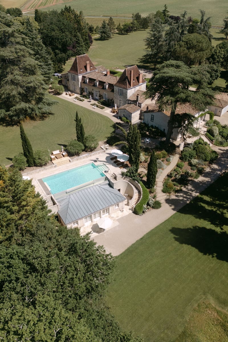 Aerial view of Château Lacanaud with its pool, gardens and surrounding Dordogne countryside