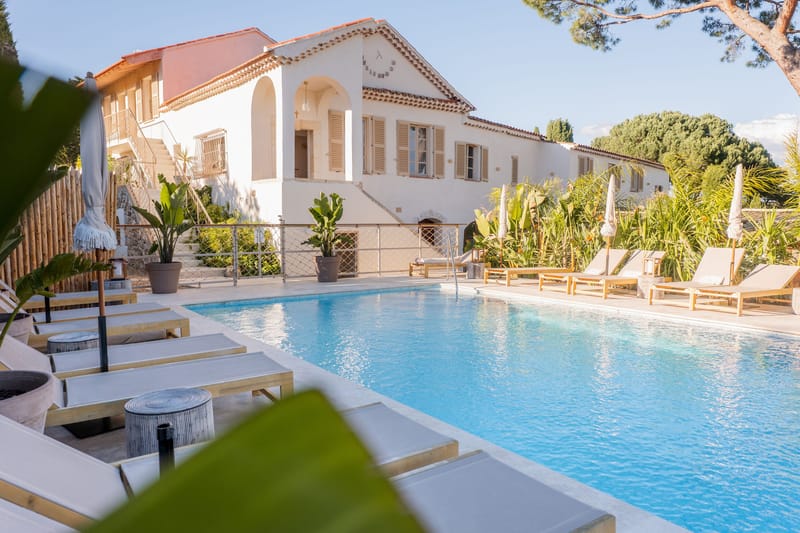 The hotel facade and the swimming pool in the garden