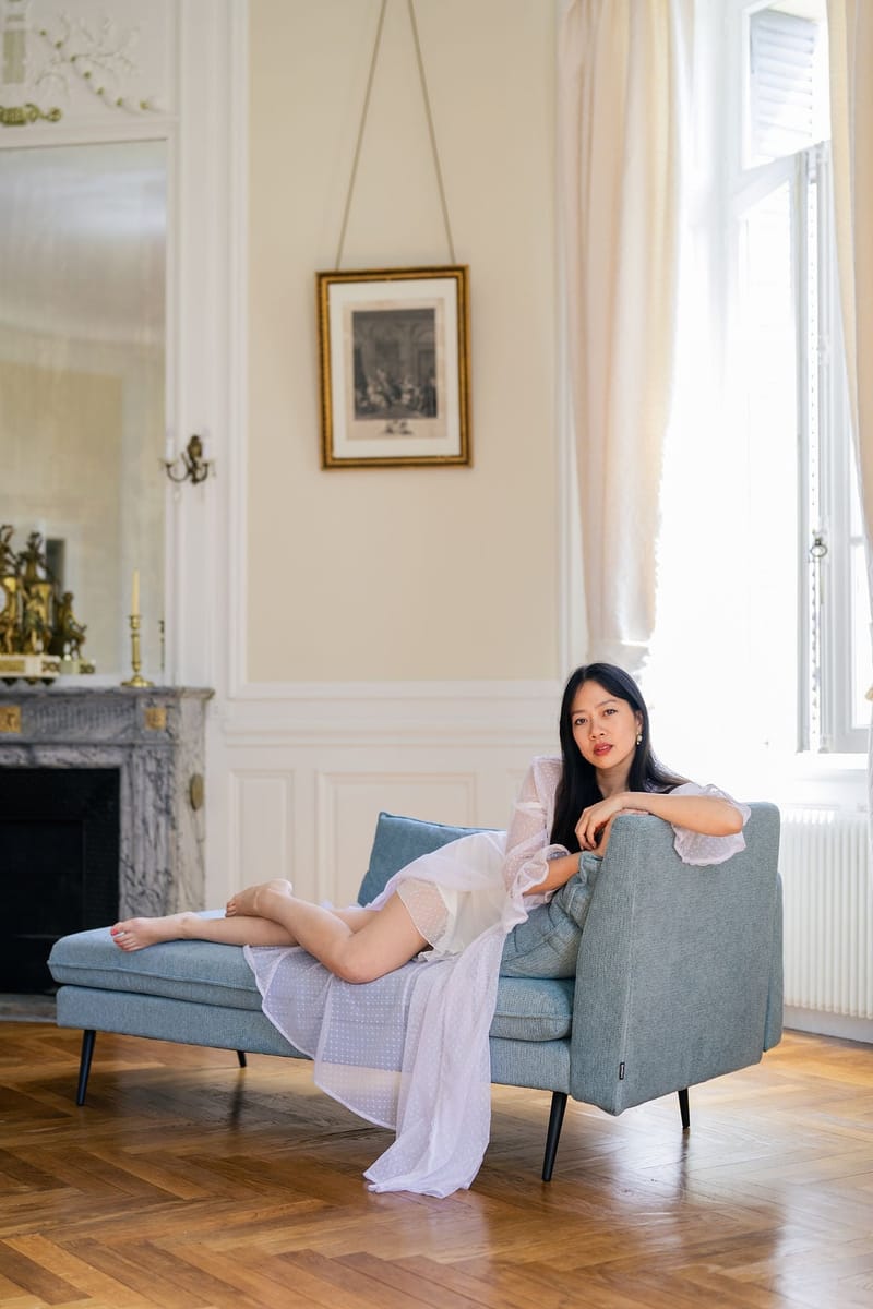 Bride on a blue daybed beside a marble fireplace in a Château du Terral bridal suite