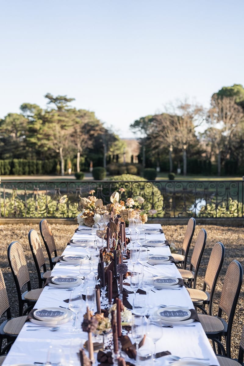 Long dinner table dressed with candles and dried flowers on a Château du Terral terrace
