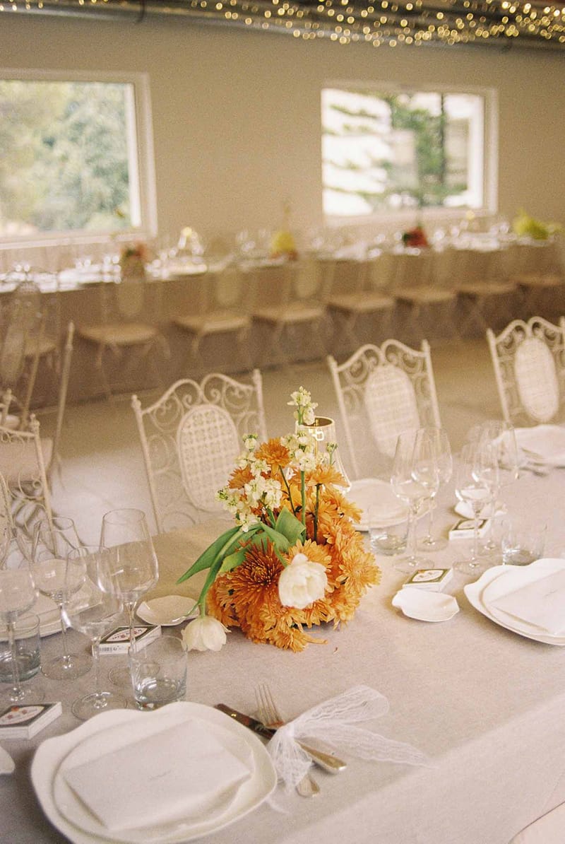 Orange flower centrepiece on a wedding dinner table at Domaine Rocabella, French Riviera