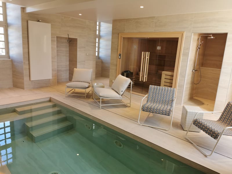 The indoor pool at Château de la Faye, with sauna, shower and loungers