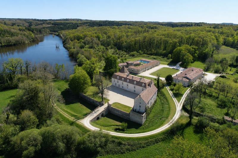 Aerial view of the estate, with the château and its walled courtyard, the outbuildings, the outdoor pool and the lake
