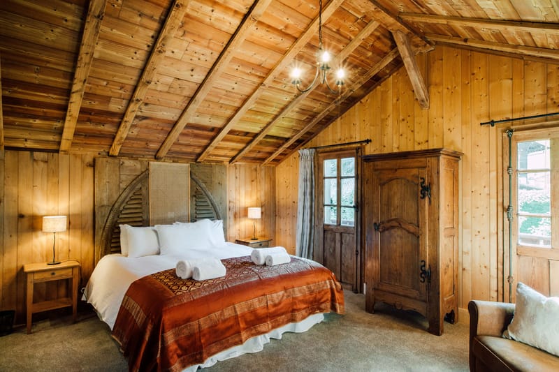 The Atelier bridal suite, with a beamed wooden ceiling and a bed under the eaves