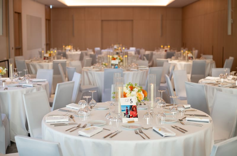 Event room at Montcalm Nice set with round tables, white linen and orange and white flowers