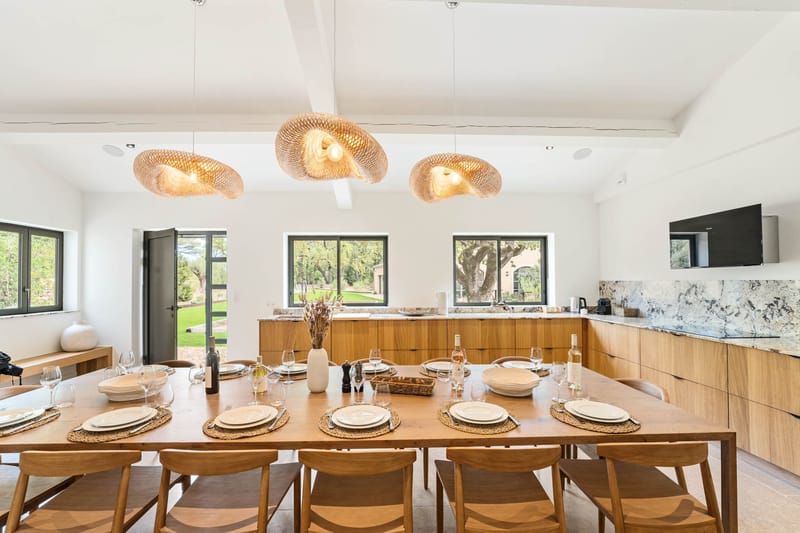 Domaine de Blacailloux bastide modern kitchen dining room with wooden table and woven pendant lights
