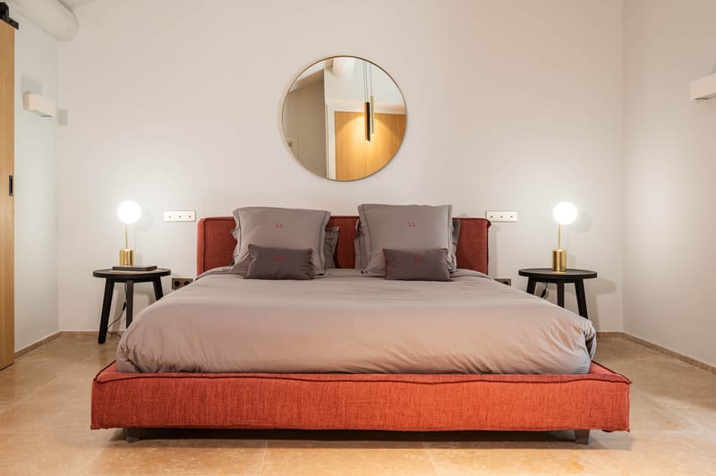 Domaine de Blacailloux bastide suite with terracotta bed frame, grey bedding and brass lamps