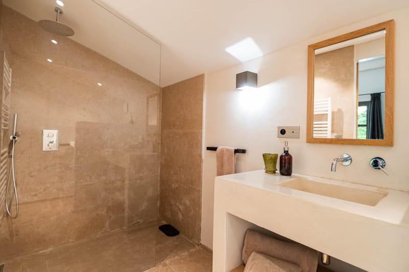 Domaine de Blacailloux bastide bathroom with stone rainfall shower and modern vanity