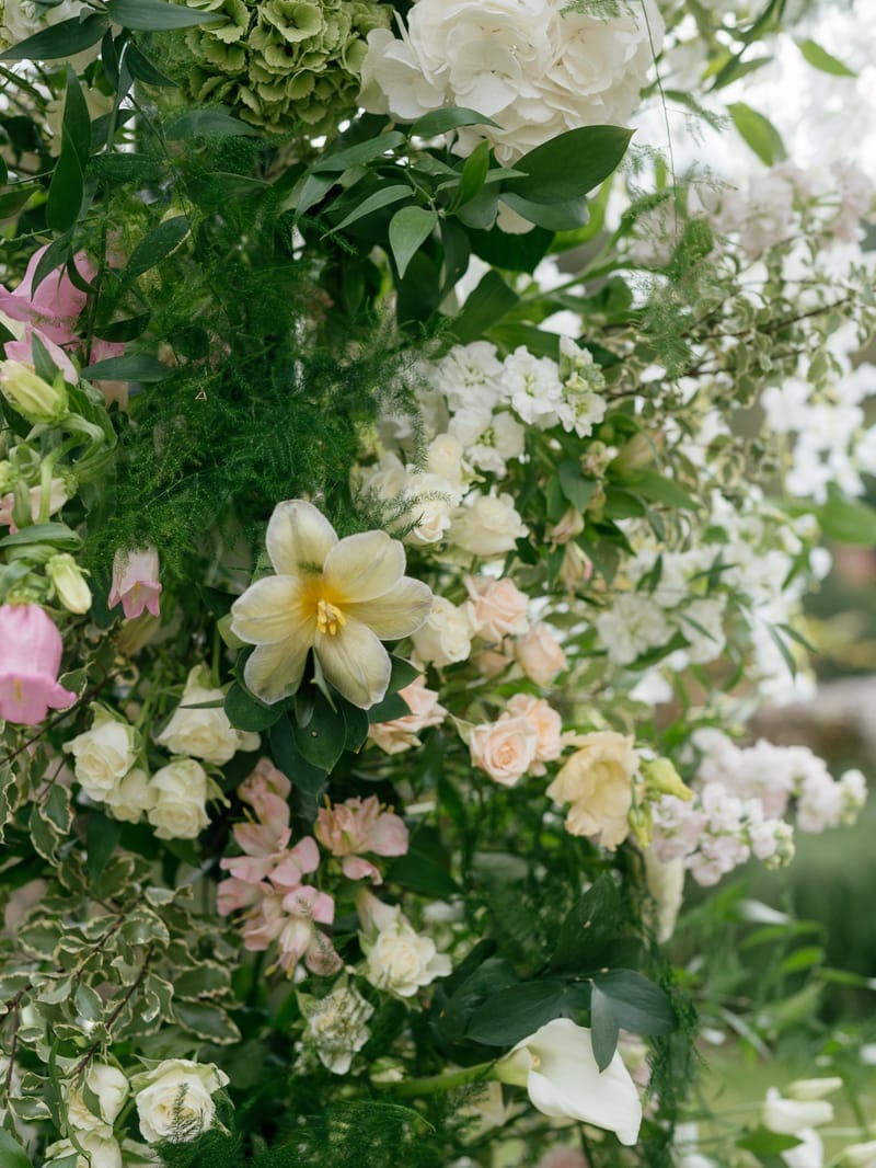 Close view of a floral installation of white hydrangeas, pale roses, pink foxgloves and greenery