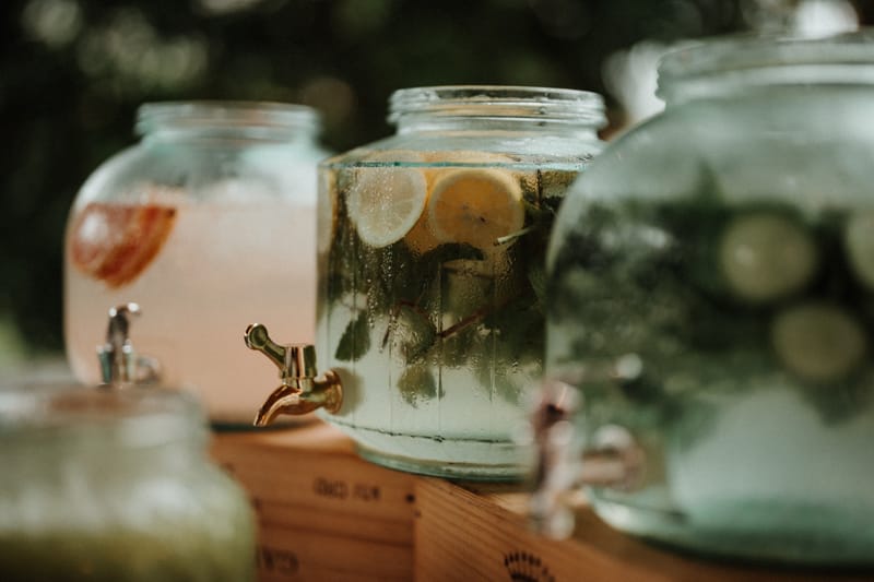 Glass drink dispensers with infused water and lemonade at a Chateau du Pordor drinks station
