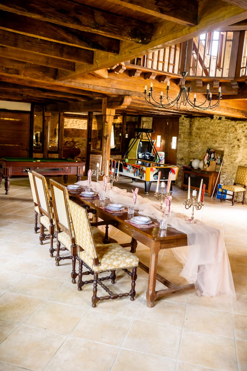 Long banquet table set beneath the beams of the timber-framed hall at Chateau Eyparsac