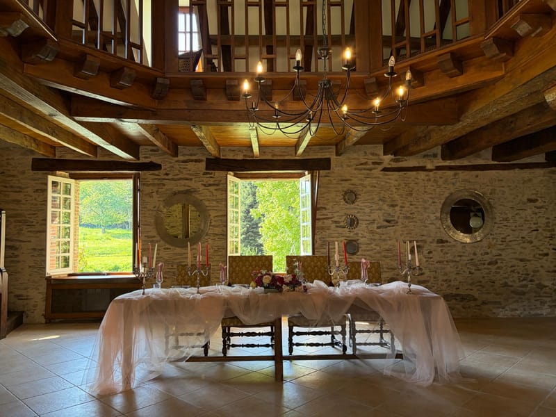 Wedding reception set with a draped ceiling and long head table in the hall at Chateau Eyparsac