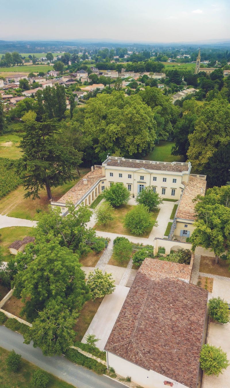 Aerial portrait of Chateau de l'Hospital showing the chateau, outbuildings and village of Portets behind