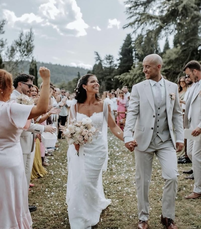 Bride and groom walk back through their guests in a shower of petals after the ceremony