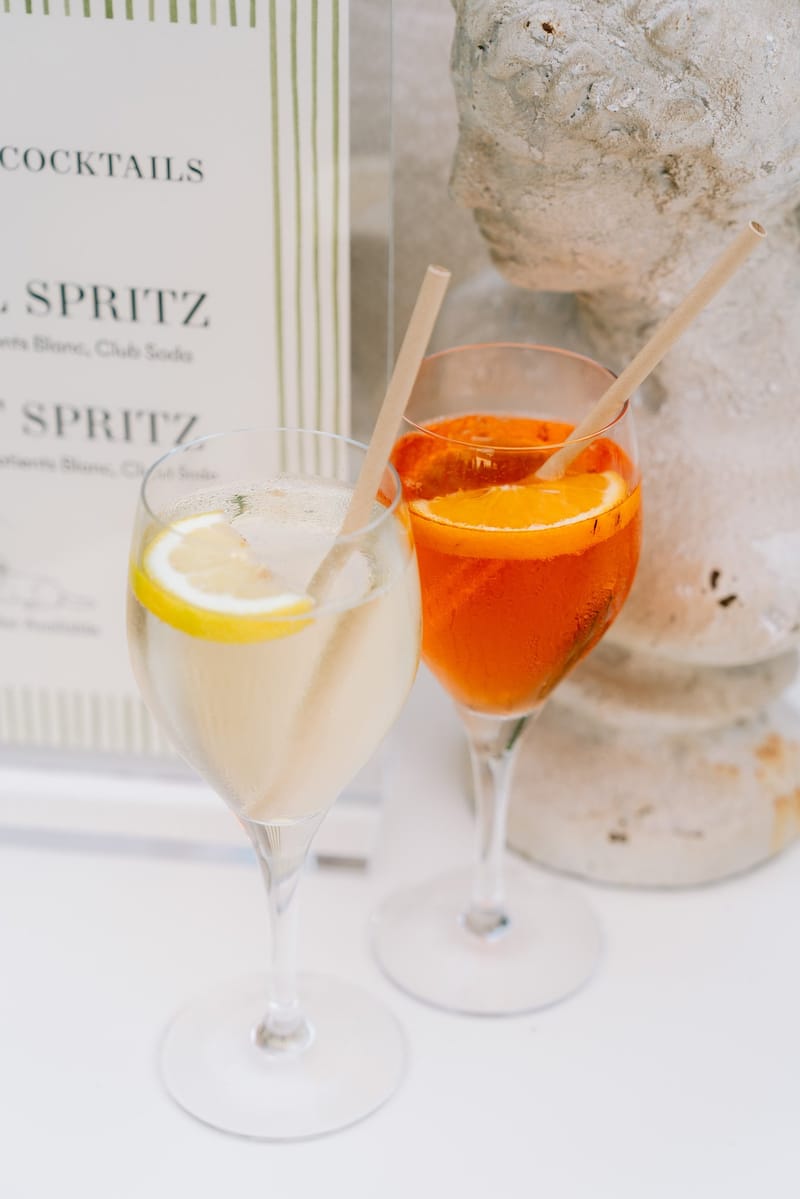 Cocktail menu displayed beside spritz glasses