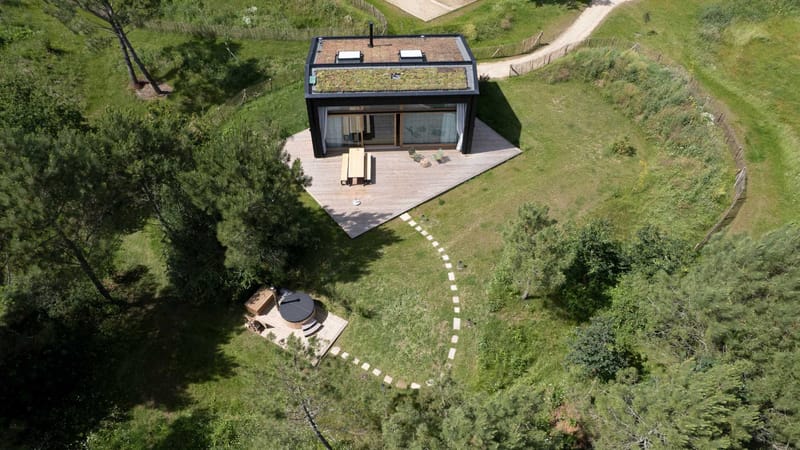 Aerial view of the eco lodge at Domaine Le Mezo with its green roof, timber deck and outdoor hot tub