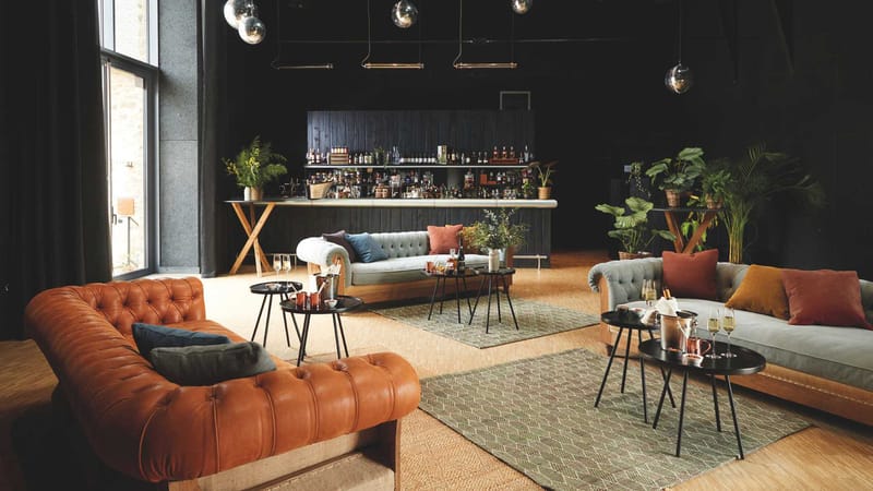 The bar at Domaine Le Mezo with tufted sofas, mirror balls and a timber clad counter