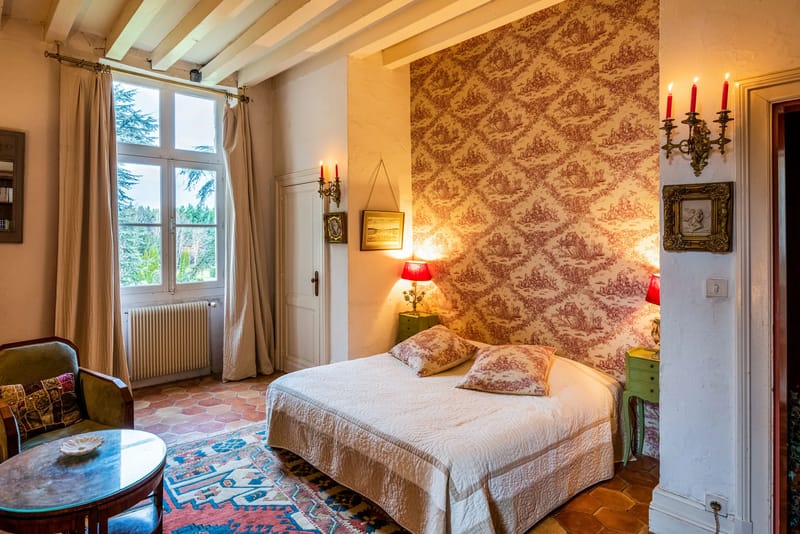 Guest bedroom with a damask wall panel, wall sconces and a double bed