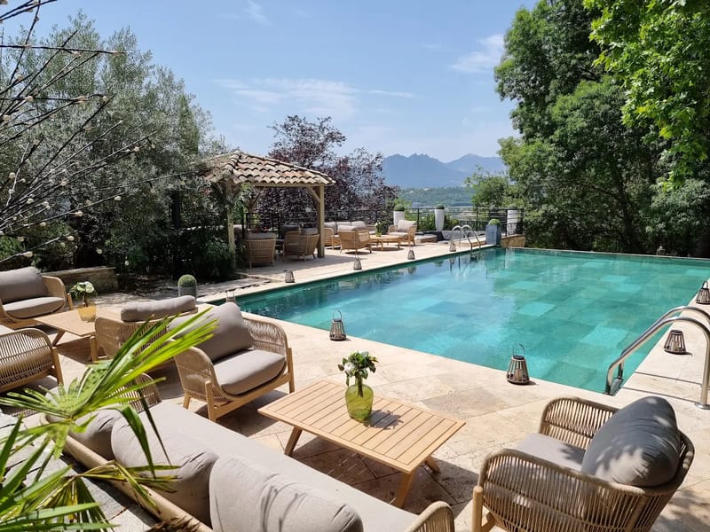 Swimming pool and stone terrace with mountain views at Le Mas des Cinq Fontaines.