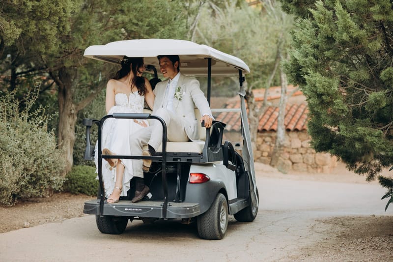 Couple driving a buggy along the estate road past the terracotta-roofed buildings at Les Oliviers de Palombaggia
