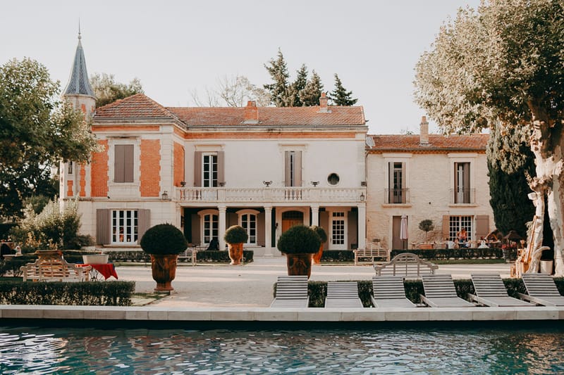 Mas D'Arvieux Provencal farmhouse exterior with turret, pool and sun loungers in Tarascon