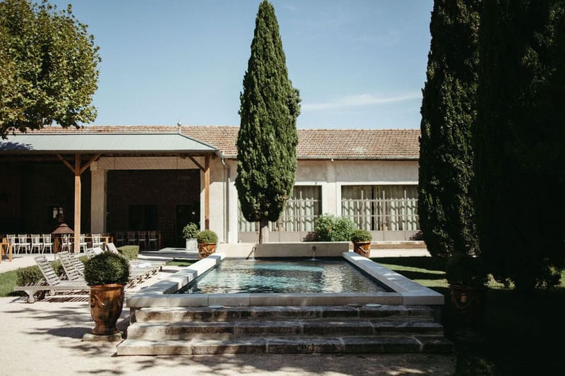 Mas D'Arvieux courtyard pool area with cypress trees and covered dining pavilion in Provence