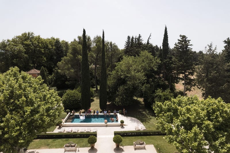 Mas D'Arvieux swimming pool and gardens with cypress trees in Provence countryside aerial view