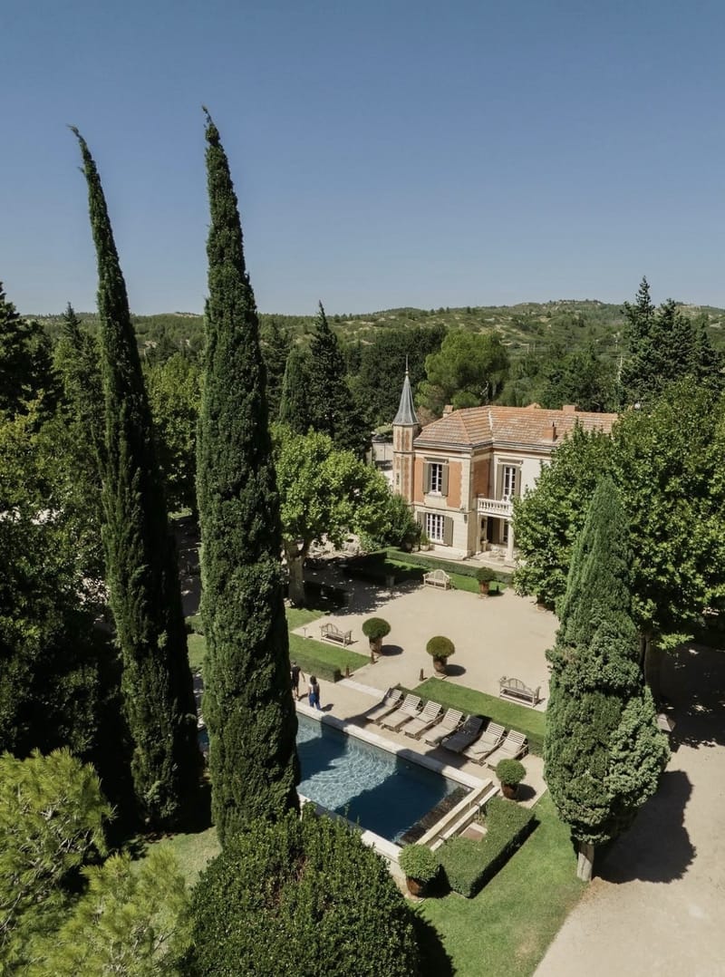Mas D'Arvieux aerial view showing Provencal farmhouse with turret, swimming pool, and cypress trees in Alpilles