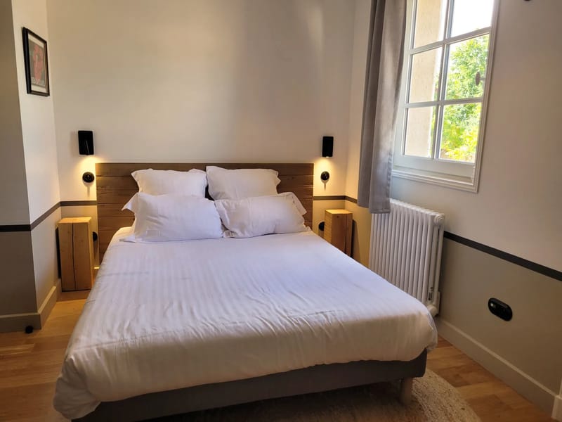 Bedroom at Domaine de Vavril with a reclaimed-wood headboard