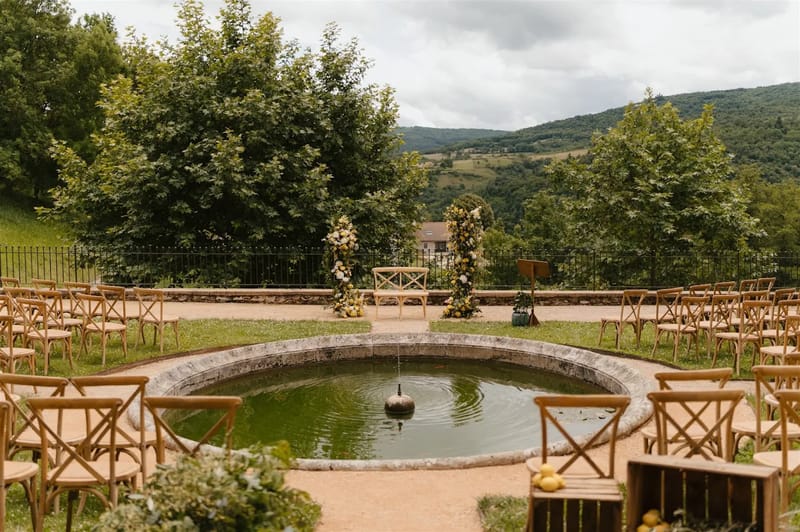 Garden wedding ceremony by the 18th-century basin at Domaine de Vavril with valley views