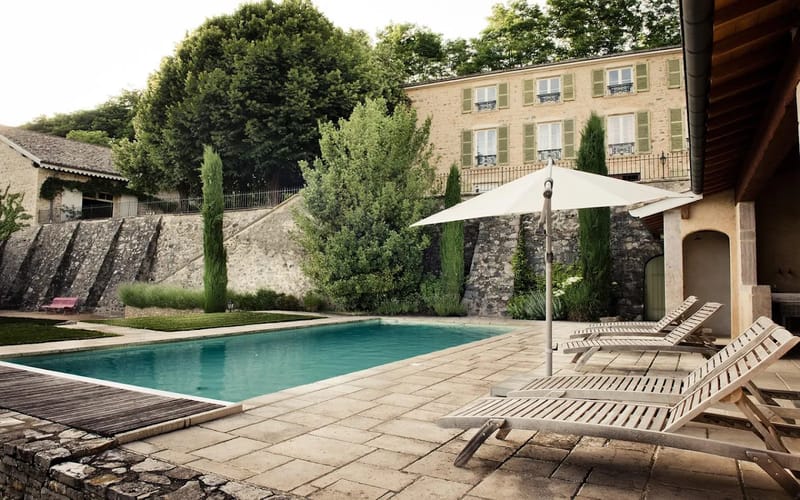 Heated pool and stone terrace at Domaine de Vavril below the maison de maitre