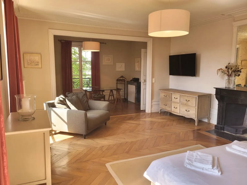 Suite lounge area at Domaine de Vavril with a fireplace and chevron parquet floor