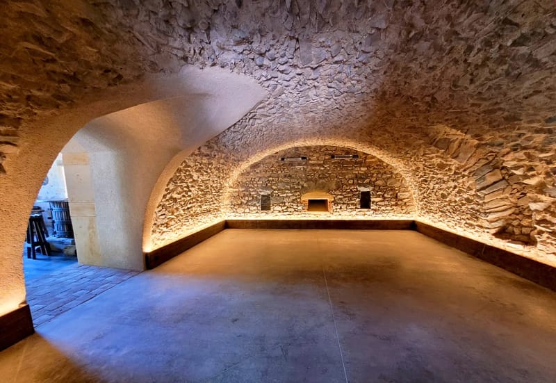 Stone vaulted wine cellar at Domaine de Vavril with an antique wine press