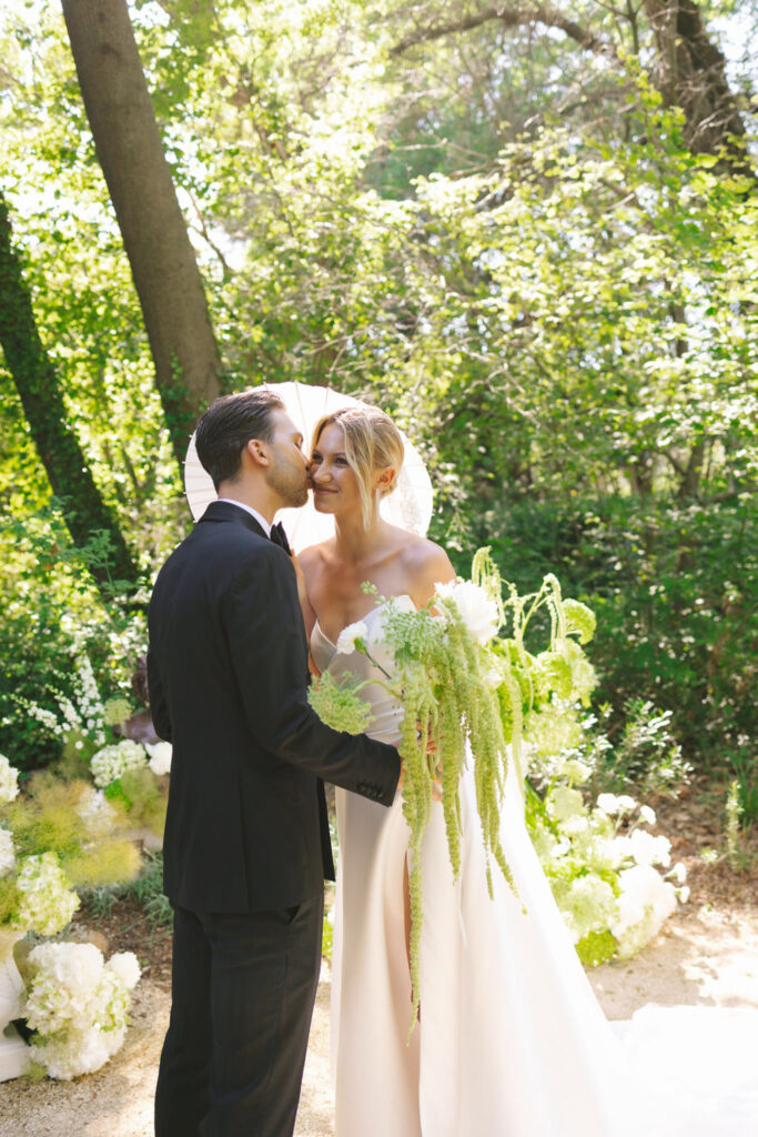 domaine de lamanon ivory romance roxane nicolas french wedding style bride groom kiss white umbrella garden