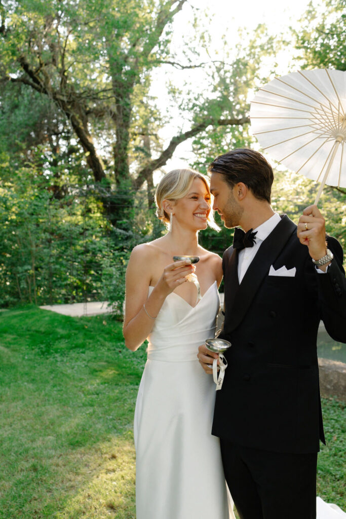 domaine de lamanon ivory romance roxane nicolas french wedding style bride holding wine glass groom umbrella looking each other