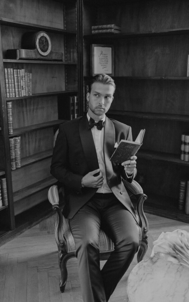 domaine de lamanon ivory romance roxane nicolas french wedding style groom holding book library black white photo