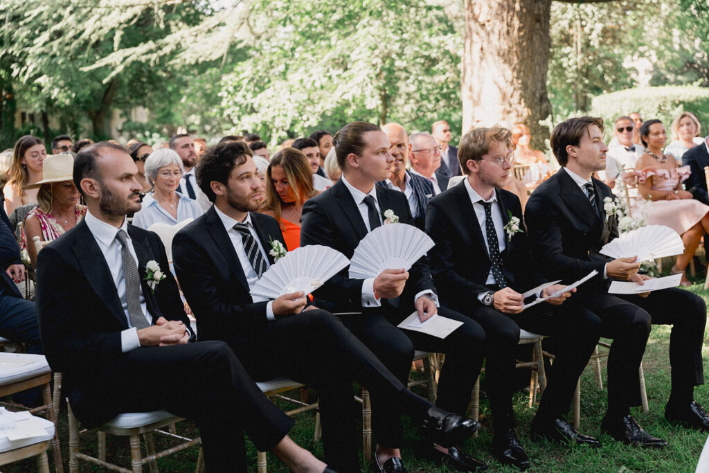 country gardens marjorie manfre french wedding style groomsmen sitting ceremony black tuxedo fan