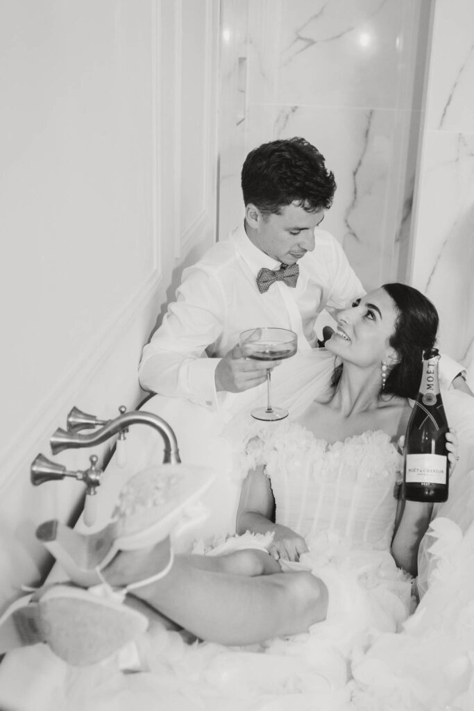 londigny k.lundford bride groom bathtub holding wine black white photo