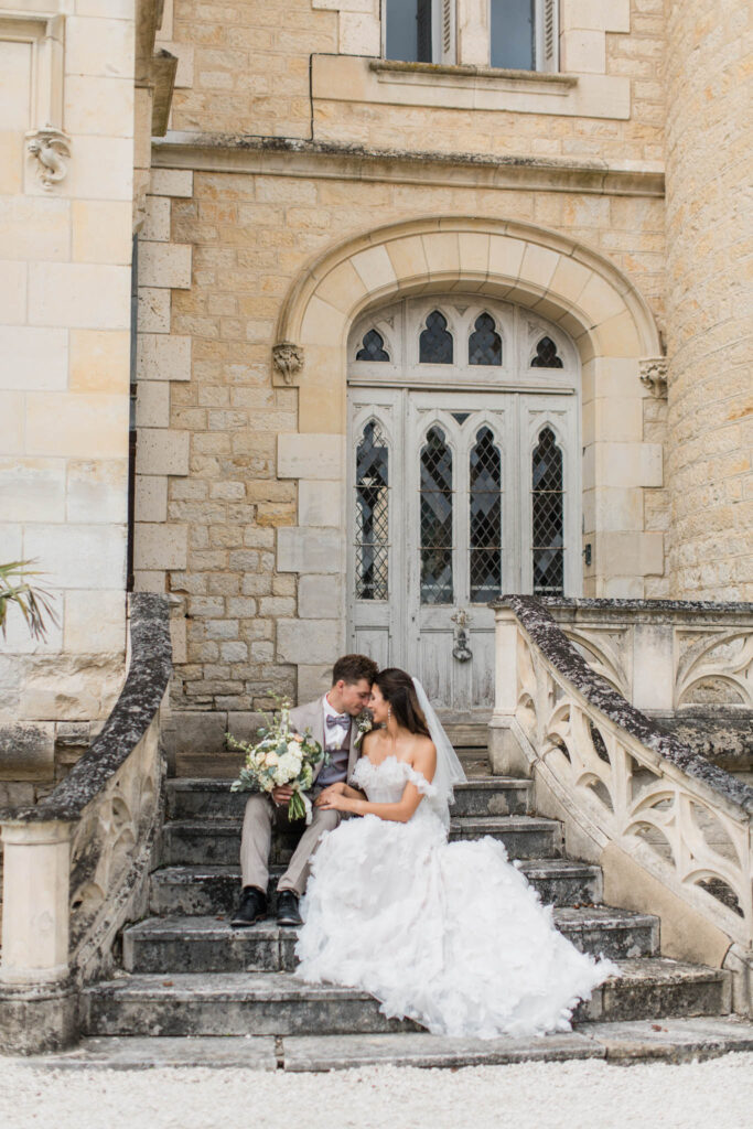 londigny k.lundford bride groom kissing outside stairs long ruffle white dress