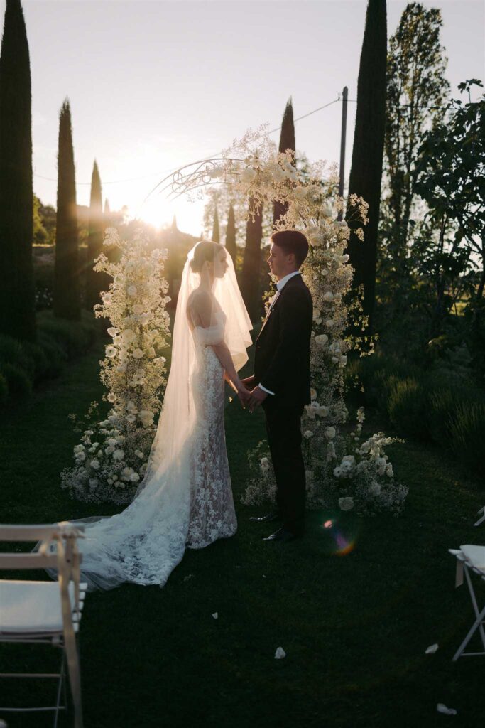 saint eusebe ayata bride groom holding hands ceremony sunset arch